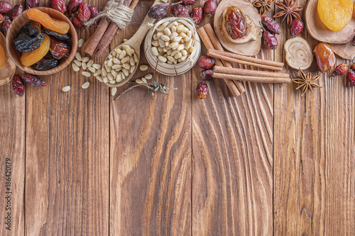 Mix of nuts, dried fruits, dried rose hips, and spices on a rustic wooden background. Concept of healthy snack. Various nuts and dried fruits.
