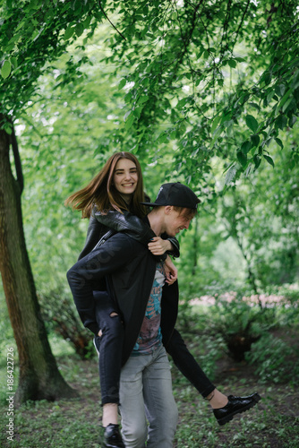 couple playing in the park while getting a piggy back ride