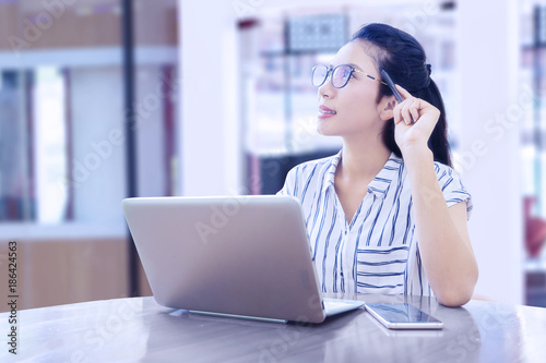 Businesswoman thinking an idea while working with laptop