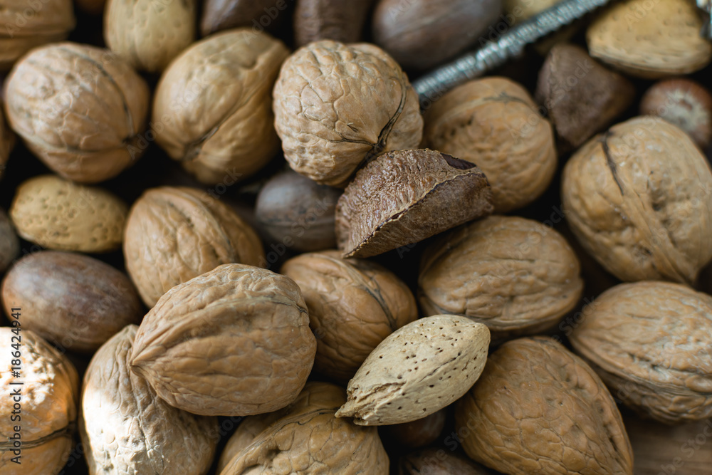 Mixed nuts background in shell. Variety of nuts with nut cracker. Mixed nuts background in shell. Variety of nuts with nut cracker.