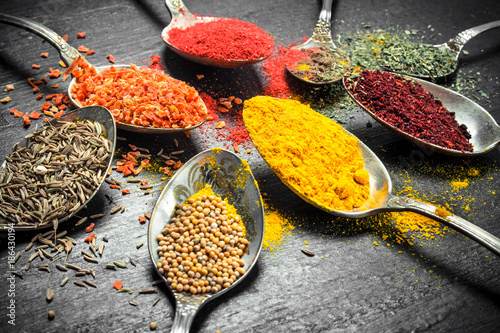 Ground spices and herbs in spoons.