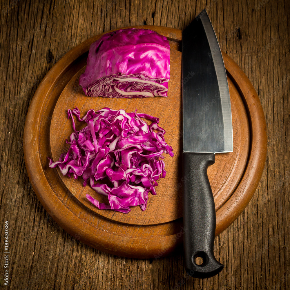 red cabbage cut slice with kitchen knife on chopping board wood. on kitchen woodden
