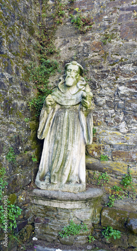 ontedeume, Galicia / Spain. July 29, 2017. Ancient medieval stone statue depicting Saint James in front of a stone wall