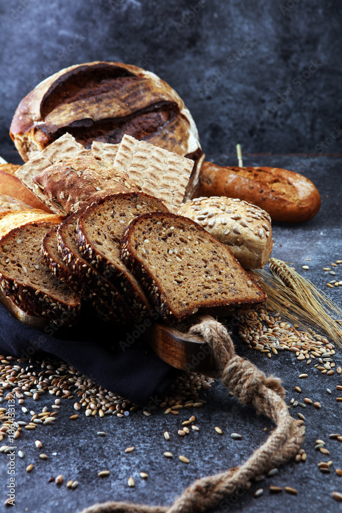 Sliced rye bread on cutting board. Whole grain rye bread and rolls with seeds. Sliced rye bread on cutting board. Whole grain rye bread and rolls with seeds.