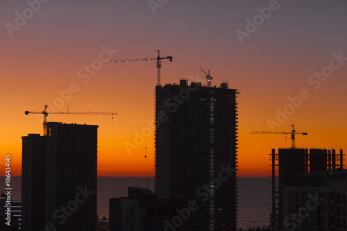 Contours of buildings under construction on a sunset background