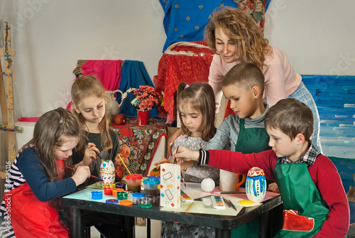 children draw at the table with the teacher