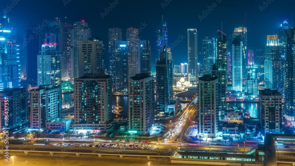 Colourful skyline of Dubai Marina by night. Scenic elevated view over the creek with skyscrapers and highways. 4K time lapse. Scenic travel and architectural background. Colourful skyline of Dubai Marina by night. Scenic elevated view over the creek with skyscrapers and highways. 4K time lapse. Scenic travel and architectural background.