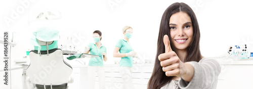 dental care concept, beautiful smiling woman hands thumbs up on dentist clinic with chair background, web banner template