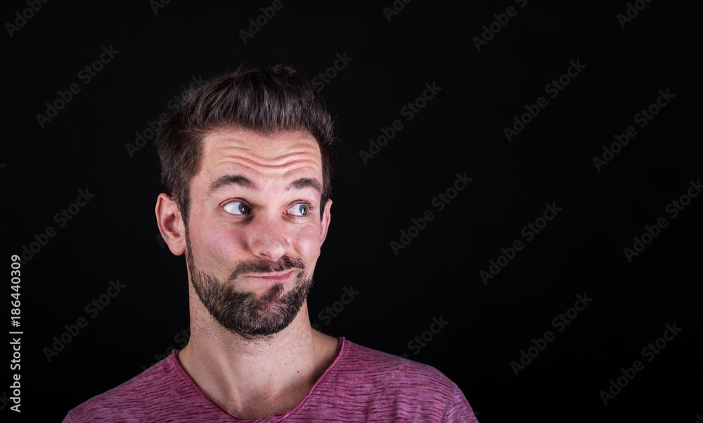 Misstrauischer junger Mann rollt Augen nach oben Misstrauischer junger Mann rollt Augen nach oben