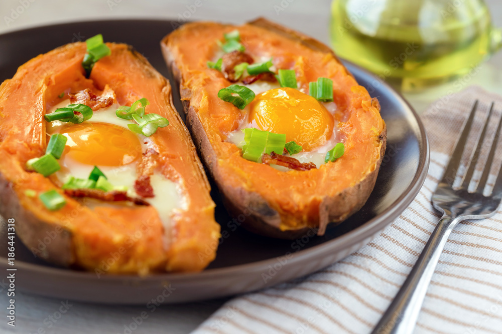 Baked sweet potato with fried egg, bacon and chives.