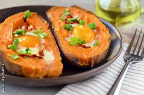 Baked sweet potato with fried egg, bacon and chives.