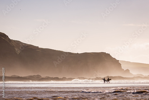 Surfers leaving the ocean photo