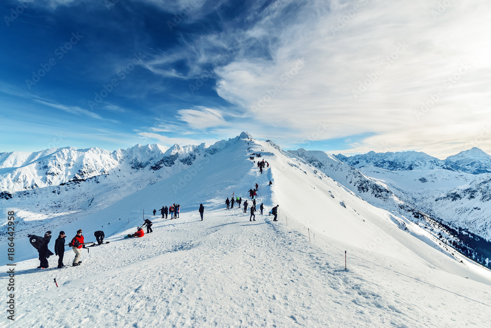 Obraz premium Rano zdjęcie turystów chodzących po zaśnieżonych Tatrach Wysokich.
