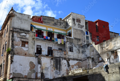reste eines abgebrochenen Haus, im hintergrund ist der bewohnte Hausteil zu sehen, frisch gestrichen und mit gewaschener Wäsche in Havanna auf Kuba