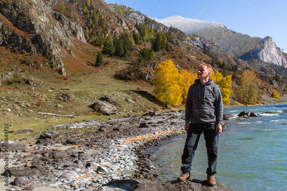 Man stands on the Bank of the Katun river in the Altai mountains, Russia.