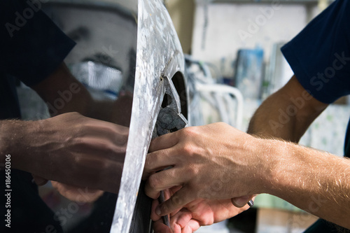 Tablou pe pânză The bodyworker repair the car bodywork in the car shop.