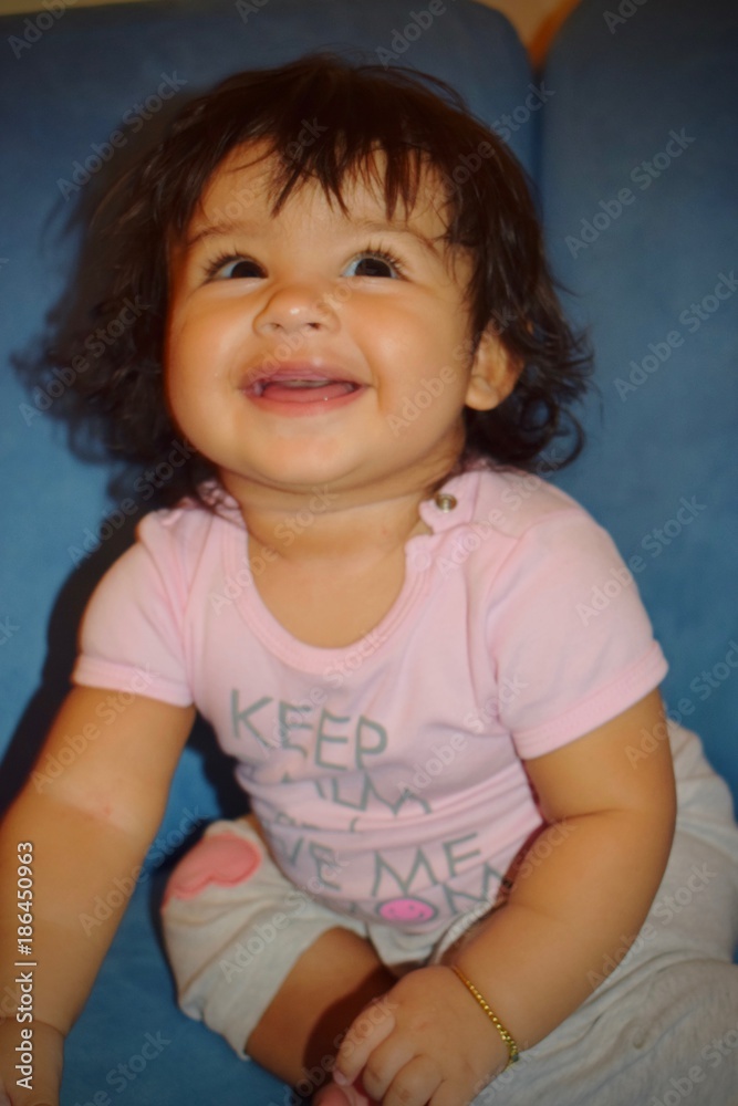 Happy beautiful little girl sitting on the sofa Happy beautiful little girl sitting on the sofa