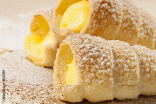 Puff pastry vanilla horns  on a wooden board photo