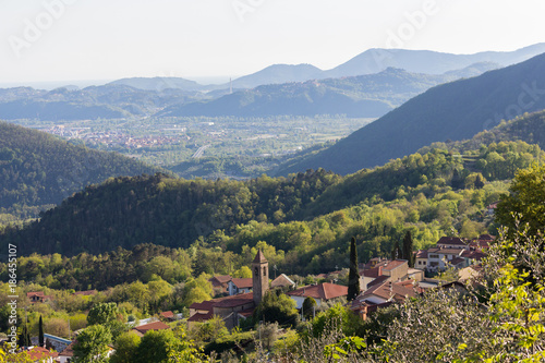 Small italian village in the hills of the northern tuscany area. View upon church and rooftops of the village in the valley. higway in the background.