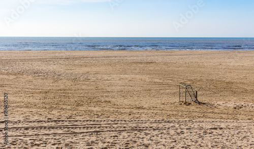 Soccer goal standing alone on the beach sand in northern holland. blue sky and the noeth sea in the background. photo