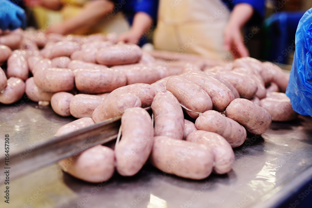 food production of sausage at a meat-packing plant. Butchers process meat