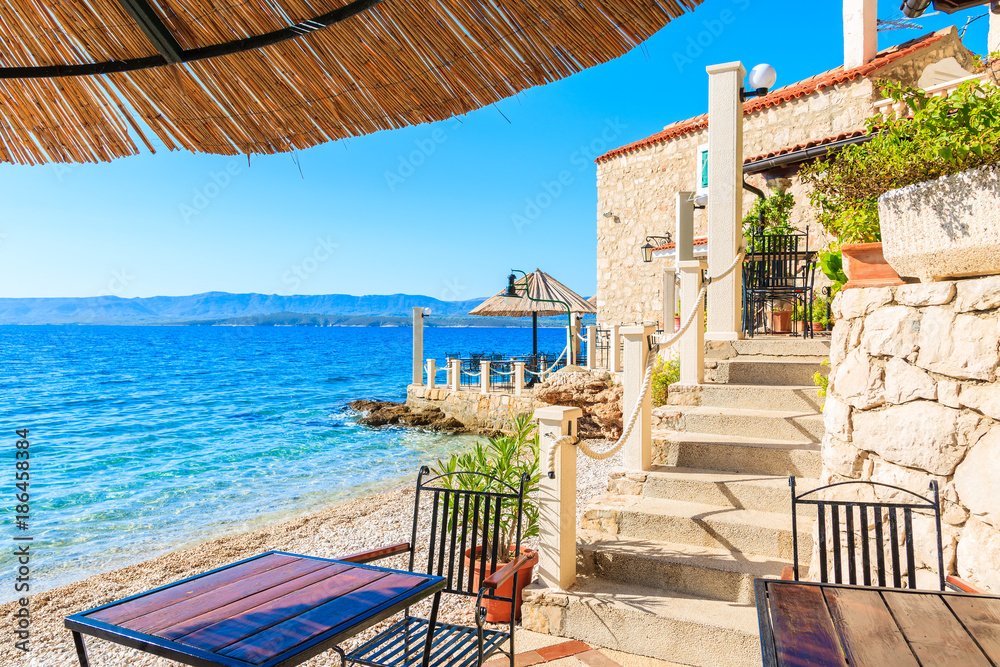 Fototapeta premium Small coastal restaurant on beach in Bol town, Brac island, Croatia