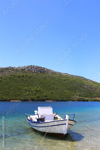 fishing boat on the background of the green mountain sithonia greece