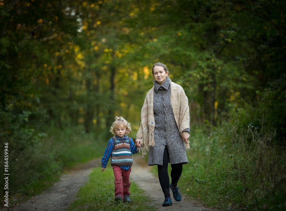 Fototapeta premium Mother and son together in forest. Family in autumnal forest.