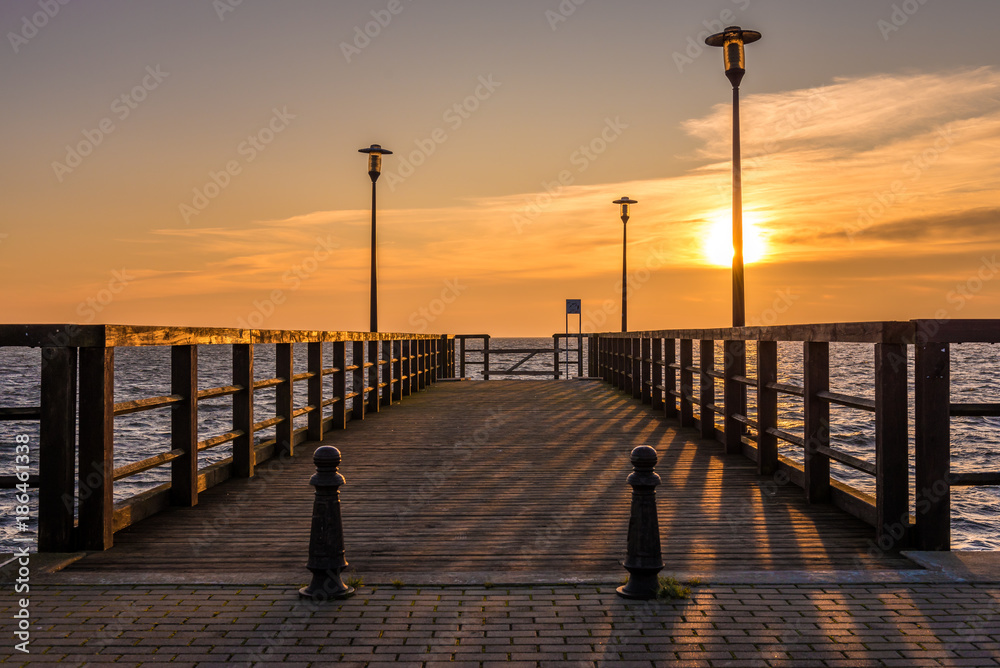 Wooden pier with view of Baltic Sea at sunset time. Hel Peninsula,Kuznica village in Poland.