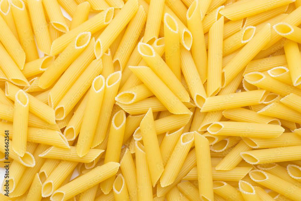 Penne rigate background top view a lot of dry raw pasta pieces. Penne rigate background top view a lot of dry raw pasta pieces.