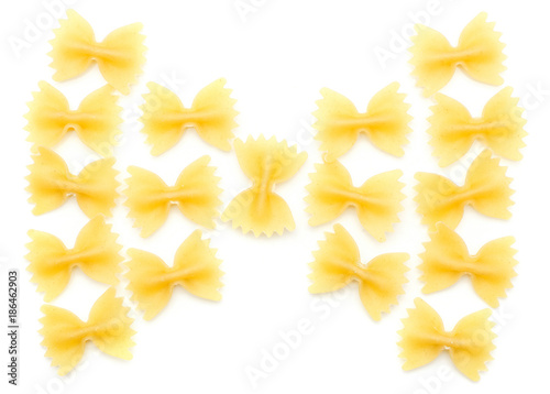 Raw farfalle folded in bow top view isolated on white background a lot of dry pasta pieces.