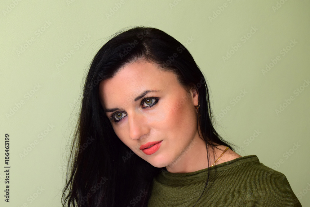Portrait young, beautiful, women. The woman has green eyes and black hair. The woman is dressed in a green jacket.. Portrait young, beautiful, women. The woman has green eyes and black hair. The woman is dressed in a green jacket..