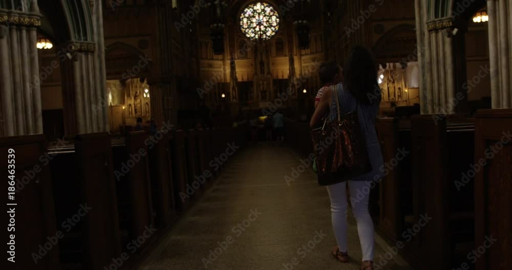 Woman holding baby walks into church - slow motion Woman holding baby walks into church - slow motion