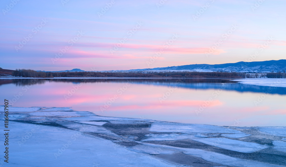 Purple Sunset - Purple sunset clouds over a melting icy mountain lake. 