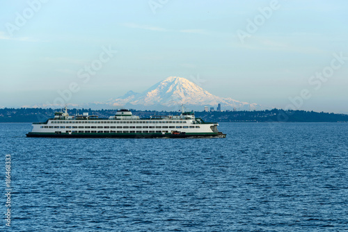 Bild auf Leinwand Edmonds–Kingston Ferry - A ferry is on its route crossing Puget Sound between Edmonds and Kingston, with Mount Rainier and Seattle Downtown shining in the evening sunlight in the background