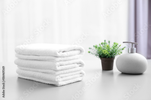 Stack of white clean towels on table in bathroom