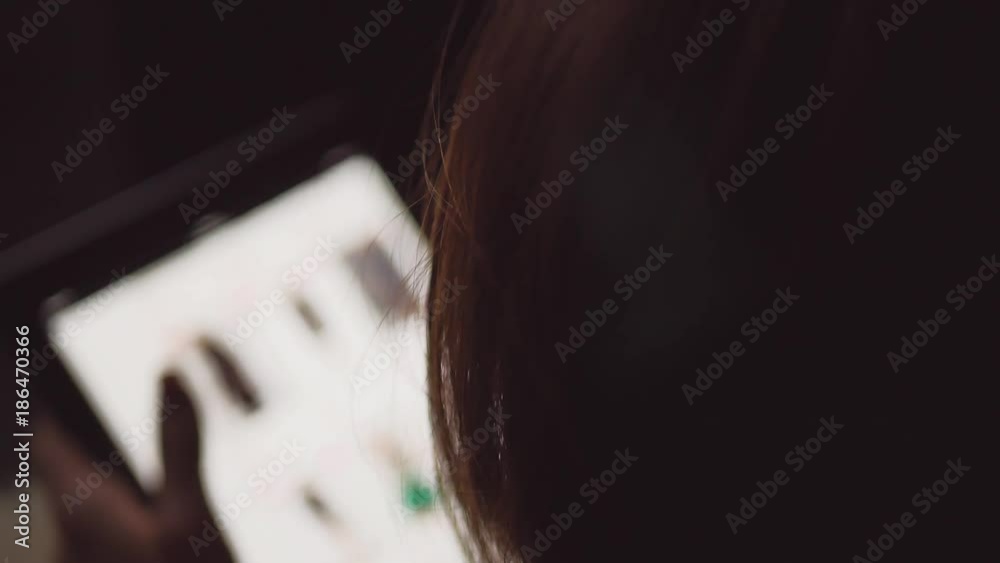Young woman sitting on the bed and makes online shopping on a tablet. Online shopping concept. Young woman sitting on the bed and makes online shopping on a tablet. Online shopping concept.