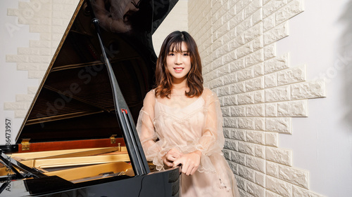 Foto Chinese girl and grand piano. Beautiful young girl pianist.