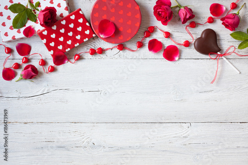 Roses and red hearts on a wooden background and gifts in boxes