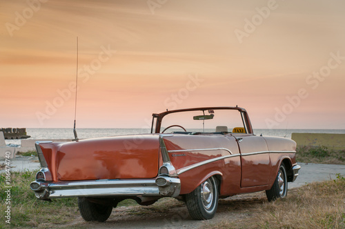 Classic convertible car at sunset on the coast of Havana. Cuba