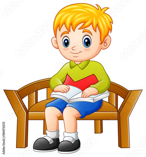 Little boy sitting on a chair reading a book