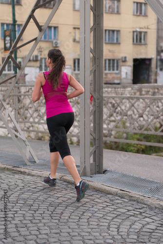 woman jogging across the bridge at sunny morning © .shock
