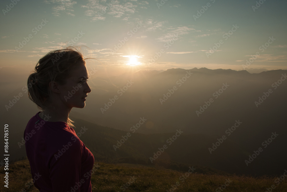 Woamn stands on a peak of mountain at sunset Woamn stands on a peak of mountain at sunset