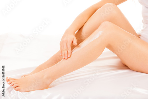 woman apply skin cream on legs