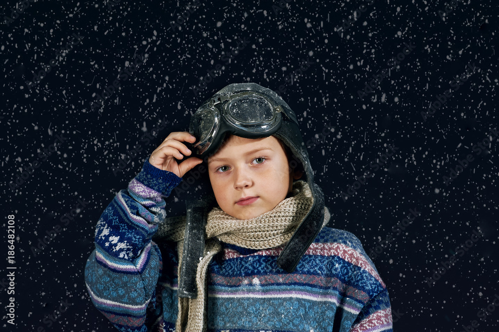 Portrait of a boy in a warm sweater and hat . Effect snowfall Portrait of a boy in a warm sweater and hat . Effect snowfall