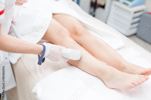 Laser epilation and cosmetology. Hair removal on ladies legs. at cosmetic beauty spa clinic. Cosmetology procedure from a therapist