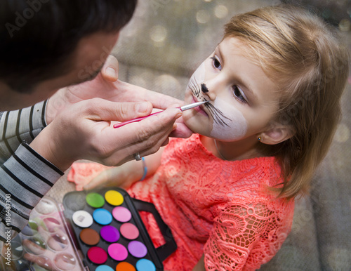 Process drawing a face painting on a child's face