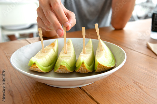 Sliced melon in dish on the wooden table.