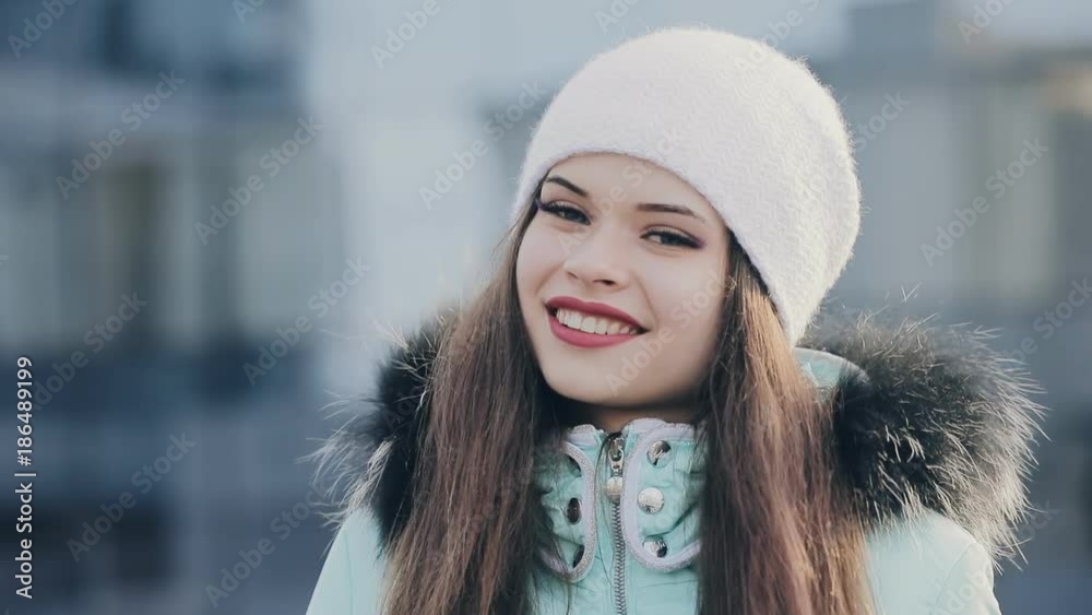 Funny pretty girl in hood and white hat at winter Funny pretty girl in hood and white hat at winter