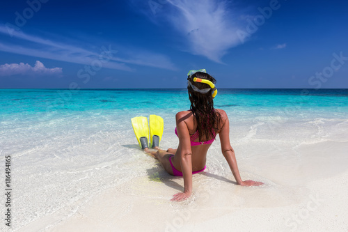 Frau im Bikini und Schwimmflossen genießt ihren Sommerurlaub in den Tropen